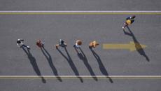 Top down view of people walking in a line on a road